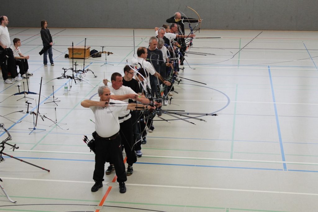 Bogenschützen an der Schießlinie beim Training in der Halle